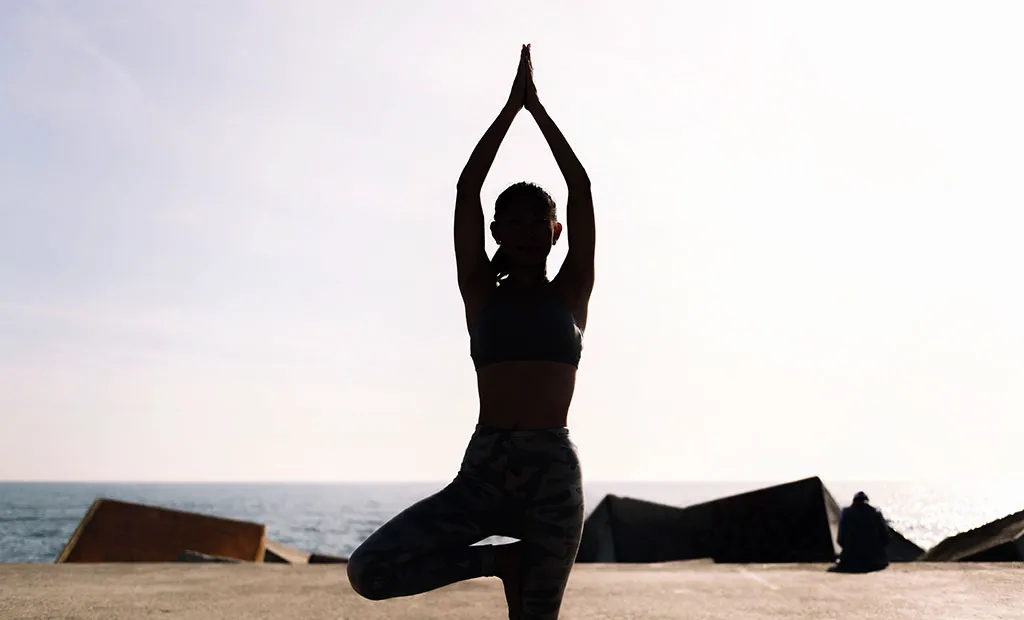 a woman standing in a tree pose