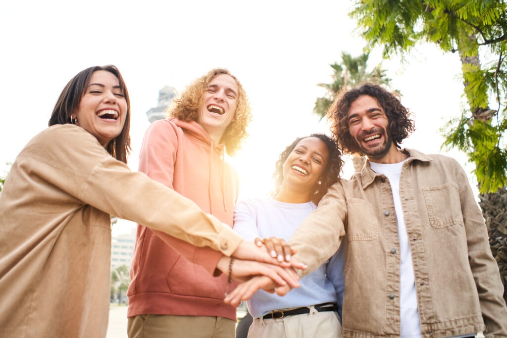 Group of young people team stacking hands outdoors